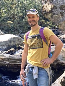 Portrait of Matt Jurjonas standing in a forest.