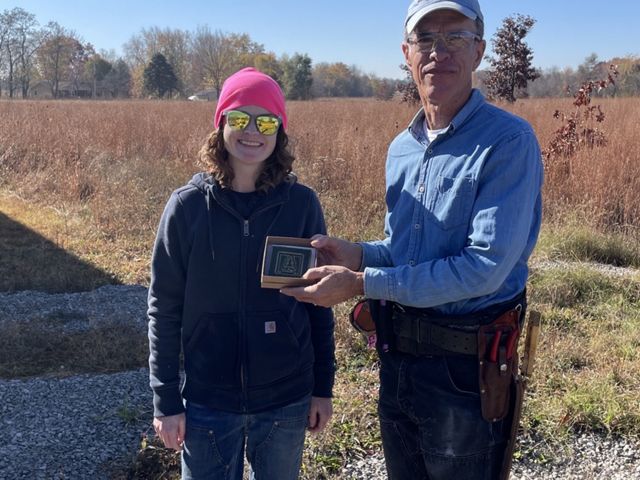 Chuck Pearson and Kim Steinberger pose with a plaque at Ives Road Fen Preserve. 