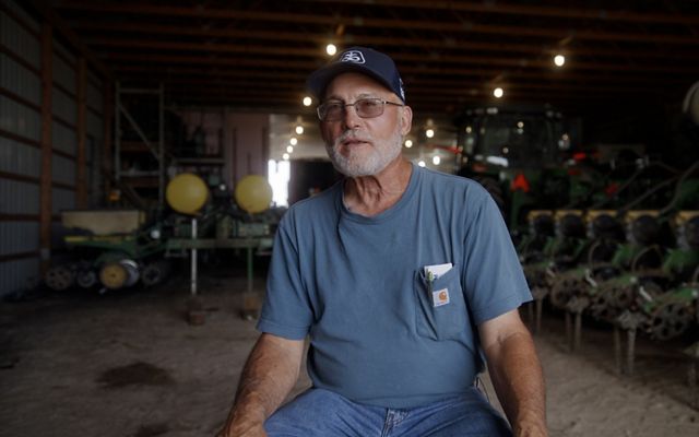Don Morse surrounded by farm equipment.