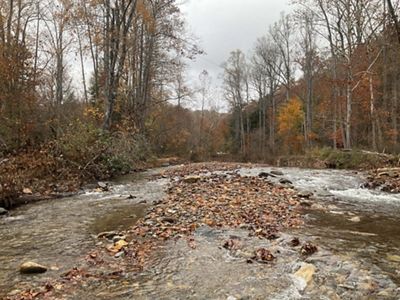 A river with rippling water and lots of small stones visible.