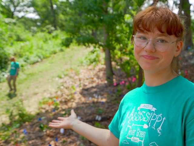 a red haired youth conservation practitioner shows off the team's newly restored hillside.