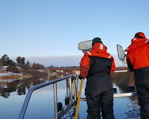 Gust Annis from TNC and Katherine Skubik from Little Traverse Bay Band of Odawa Indians, search for lake whitefish to net on a Michigan river.