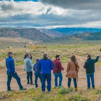 A group of people looking toward potential lands that could be used for solar development.