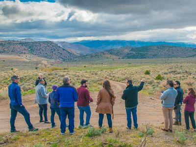 A group of people looking toward the mountains with their backs to the camera.