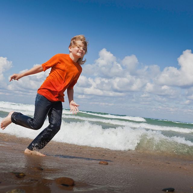 A child runs barefoot along the Lake Michigan shoreline