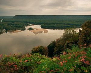A river is surrounded by a forested landscape.