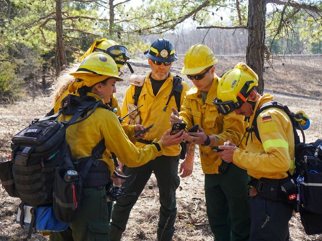 Firefighter gather in circle to go over plans.