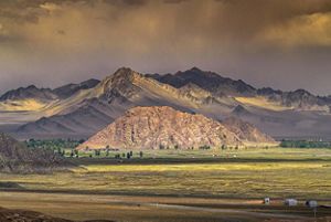Large mountains with a grassland at the base. 