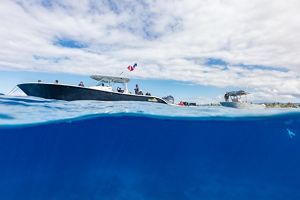 A split screen features two boats on top of blue water. 