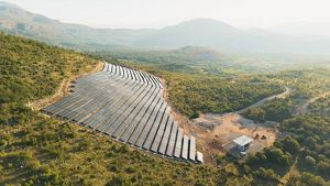 A solar farm is situated on a hillside. 