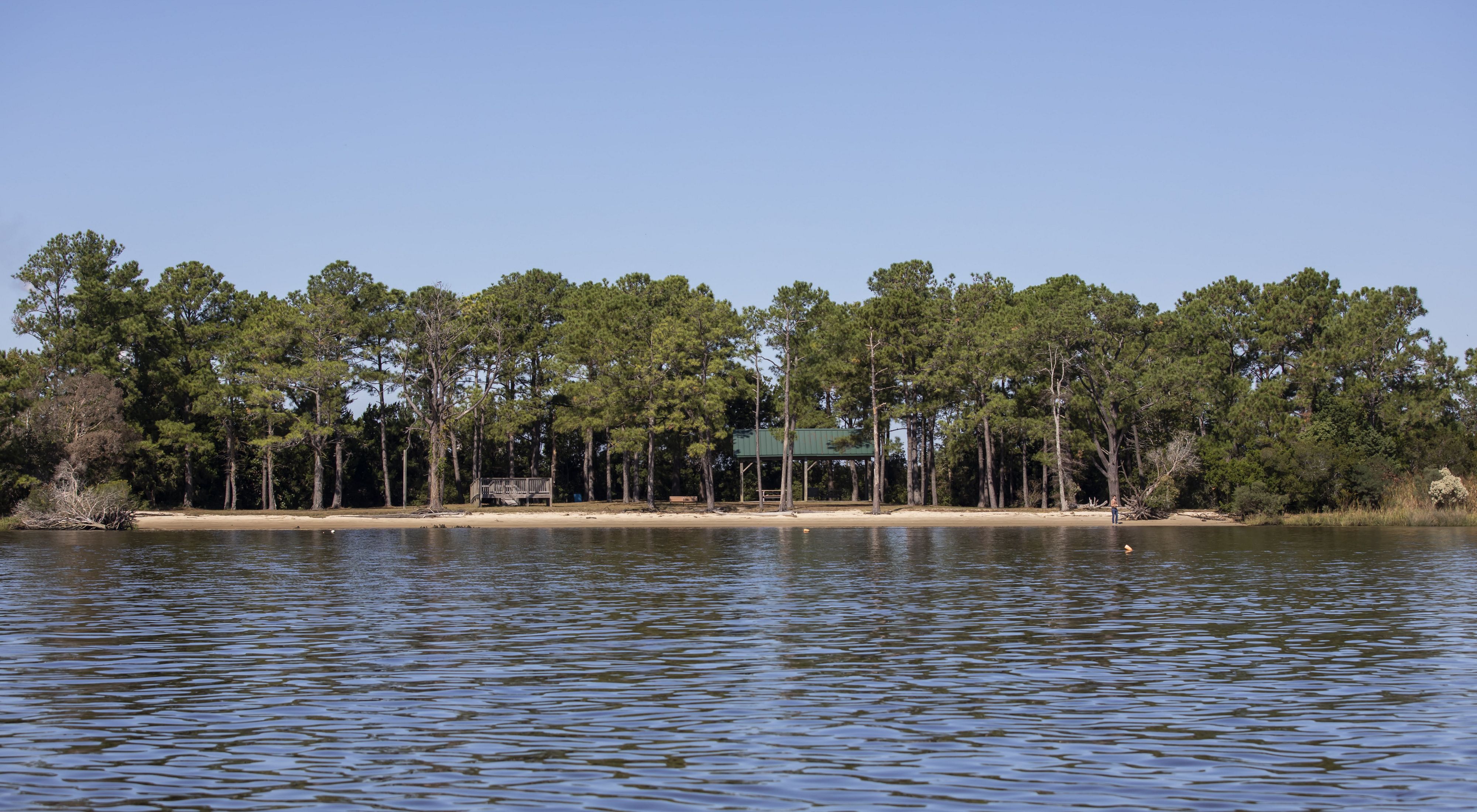 Calm waters surround a forested island.