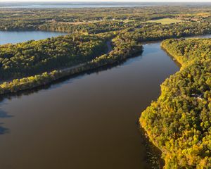 Aerial view of the wide Mississippi River headwaters flowing through forest.