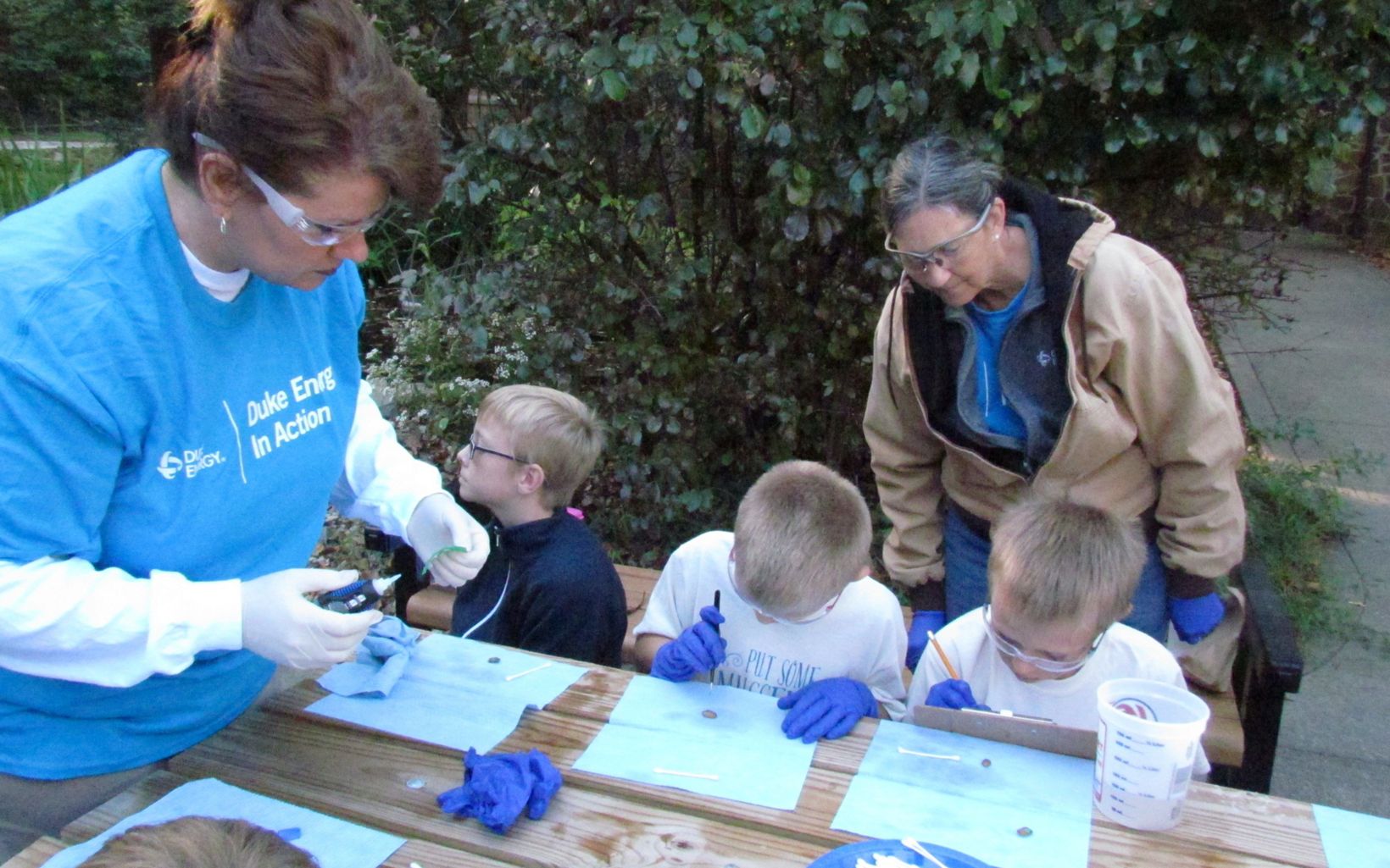 Duke Energy employees help schoolchildren tag mussels as part of TNC's mussel reintroduction program.