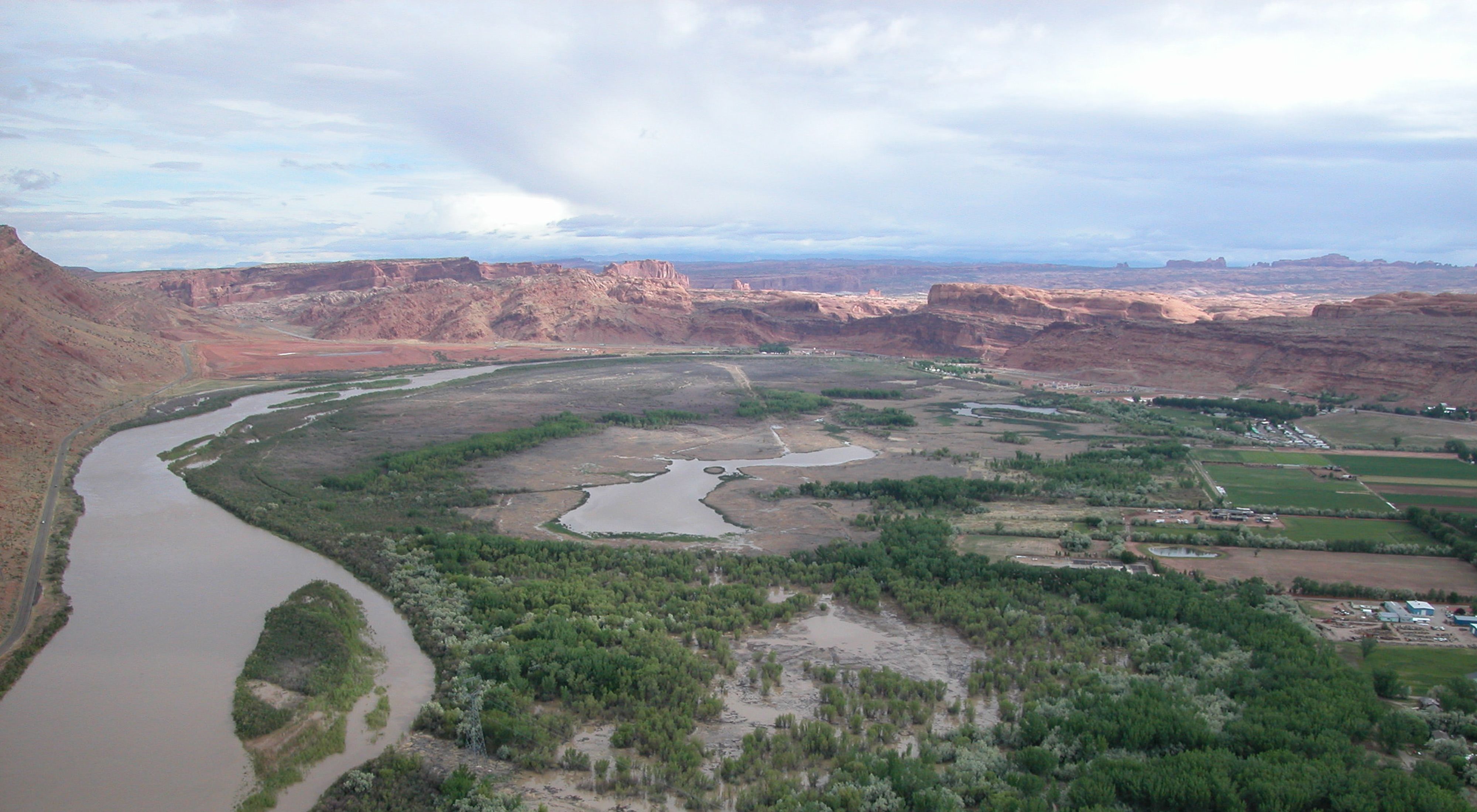An aerial view of a semi-flooded Colorado River surrounded by red rocks.