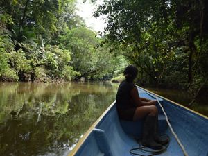 Mulher navegando em barco de um rio da Amazônia