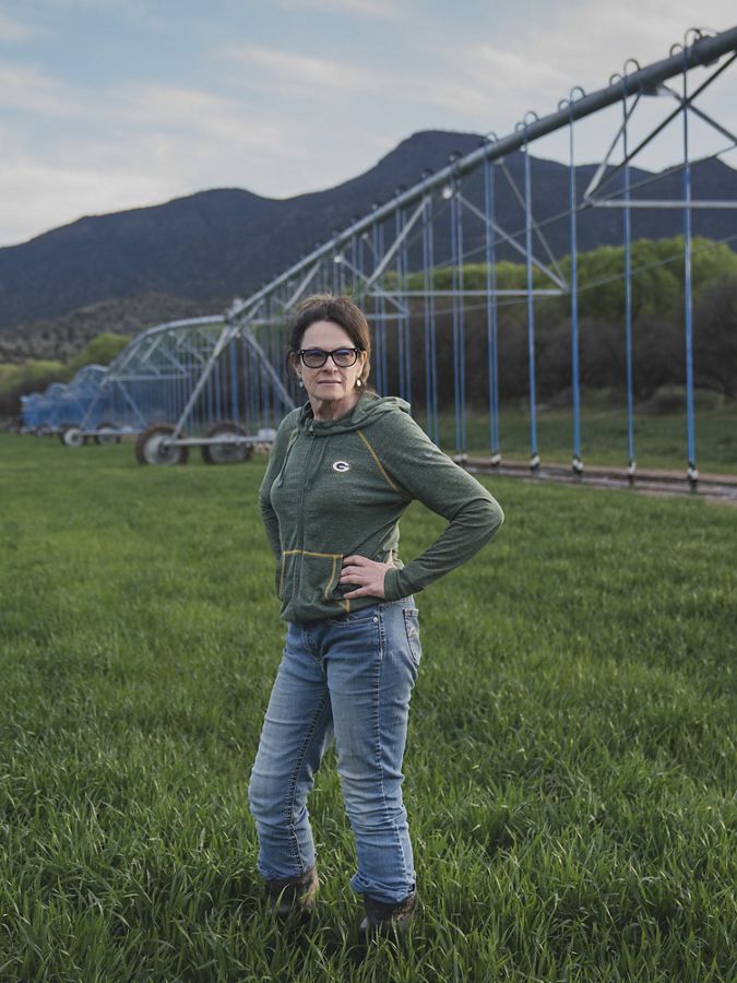 Woman standing in green jacket in an agriculture field.