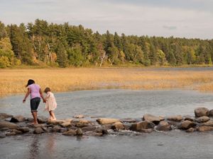 Two children walk across the headwaters of the Mississippi River at Lake Itasca