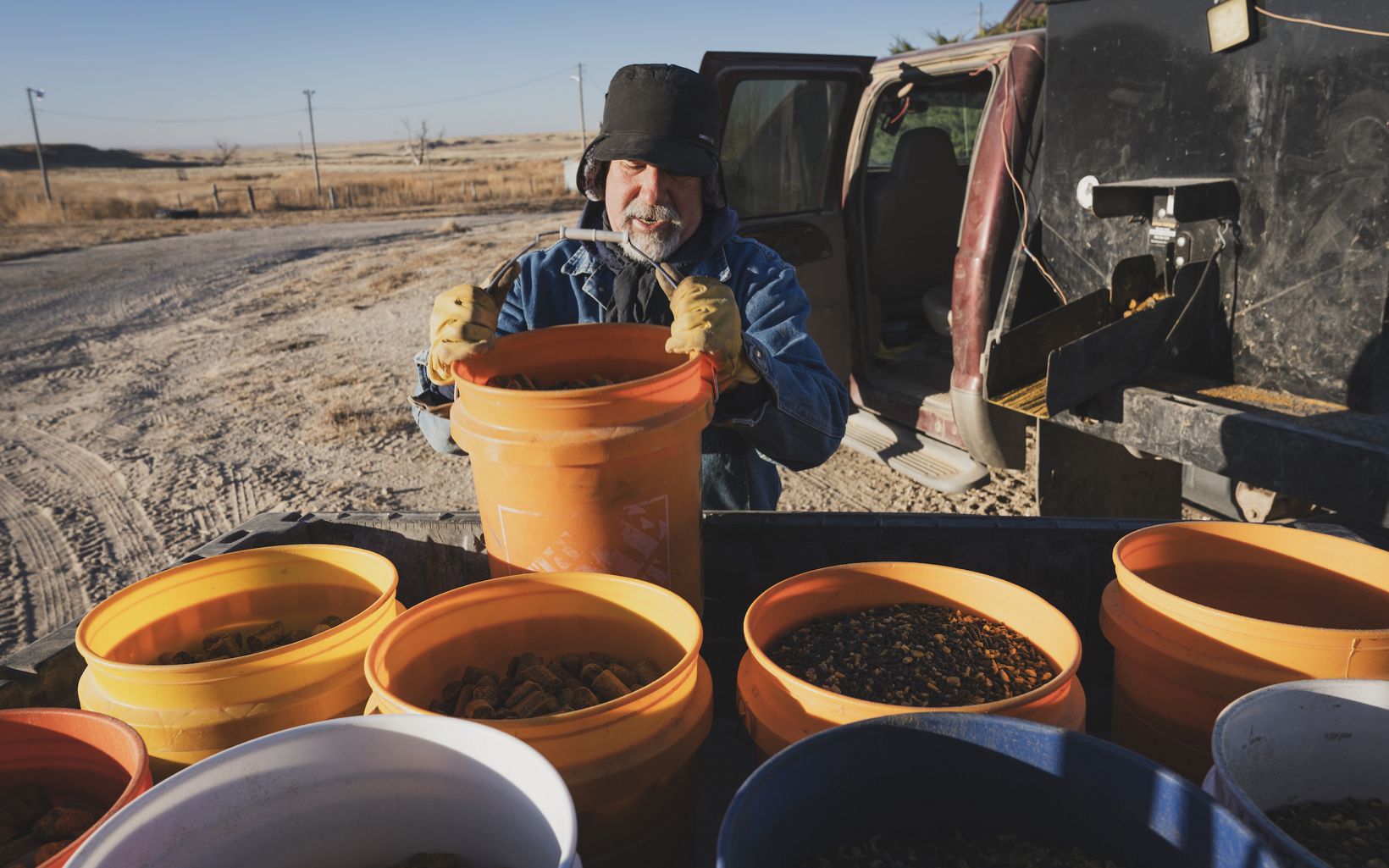Prepping Feed Treg Hatcher prepares feed buckets for goats, cattle and horses during his morning chores. © Morgan Heim 
