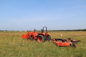 A large red industrial mower in the sandplain grassland at Bamford Preserve.