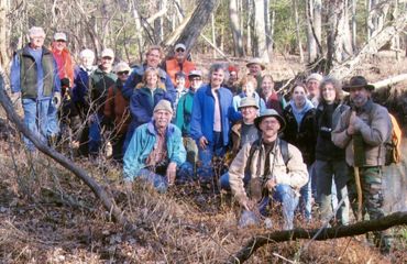 A large group of people pose together for a photo taken during a volunteer workday.