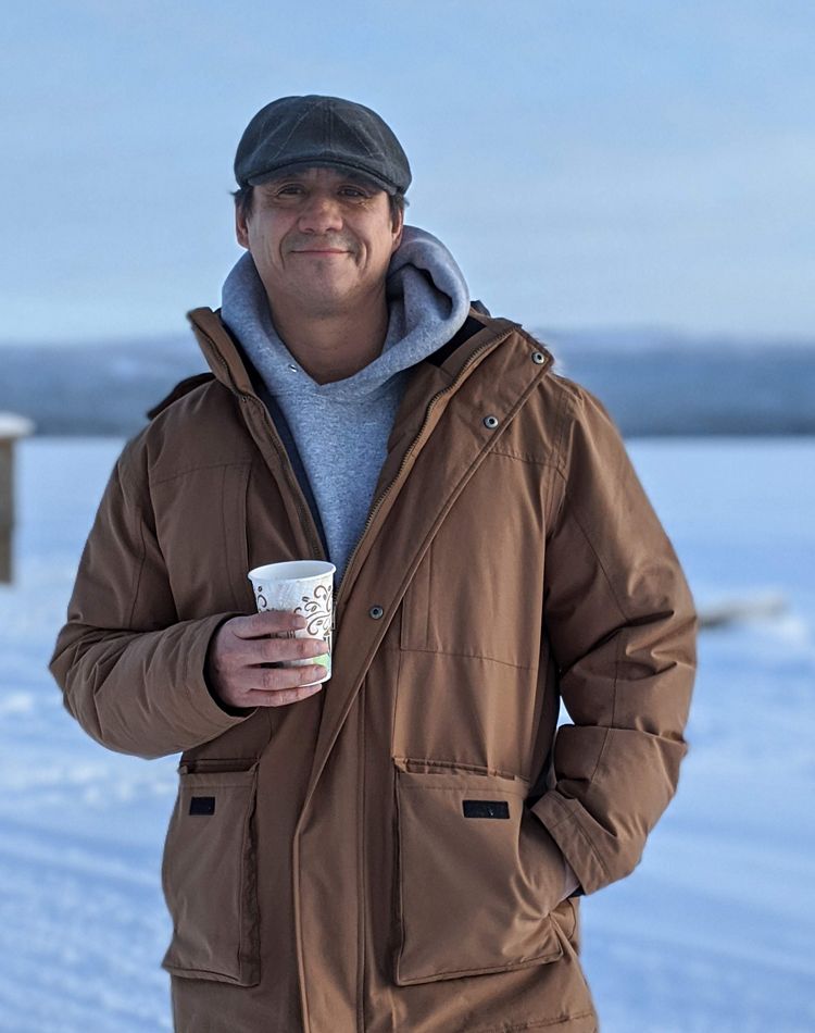 A man stands outside in a winter environment