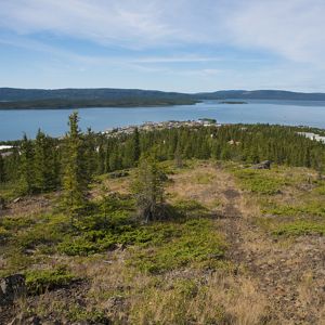 A landscape of with evergreens, lake and mountains