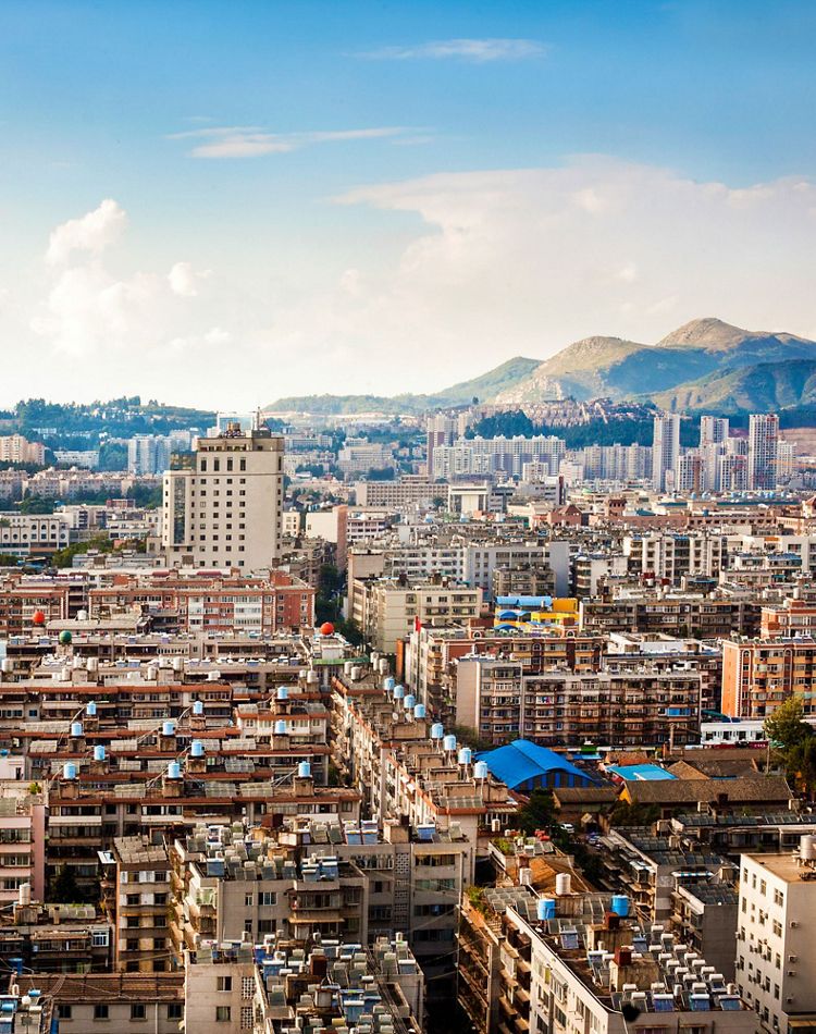 view of dense city in foreground with mountains behind
