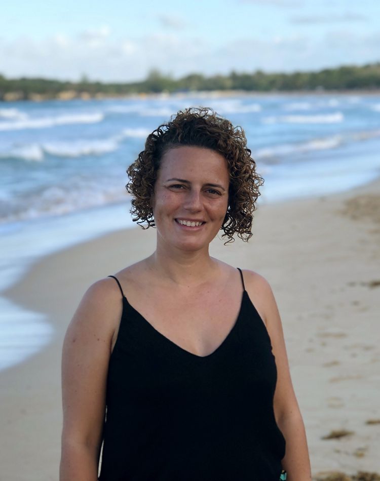 a portrait of a smiling woman on a beach