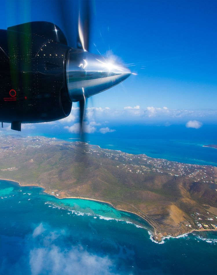 plane propellor spins with view of island in background