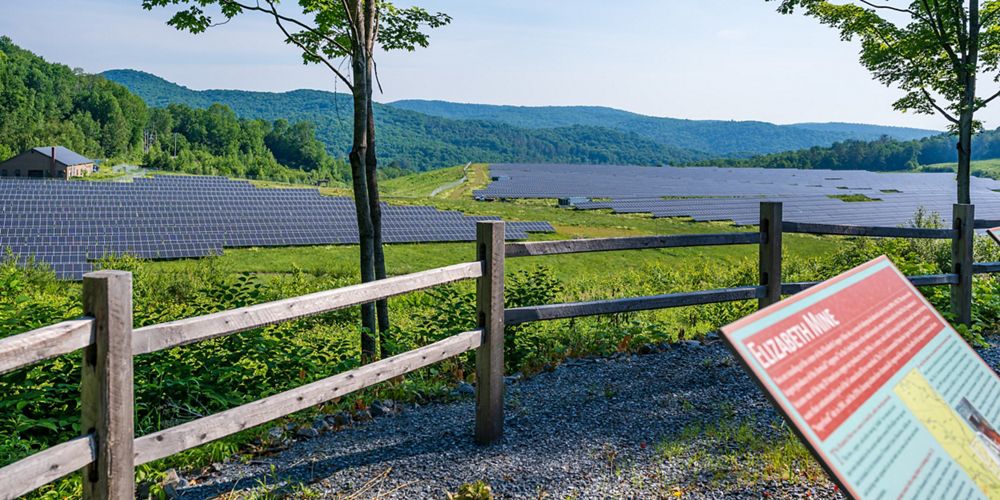 Sign that reads Elizabeth Mine with solar panel array in the background.