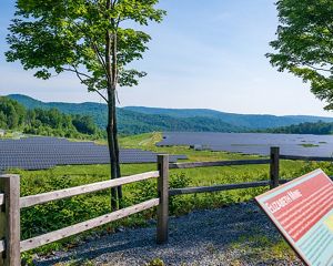 Sign that reads Elizabeth Mine with solar panels behind it.