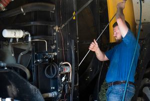 Carson Carpenter works on one of the pieces of farm equipment at Redrock View Farms.