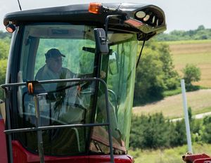 Closeup shot of the cab of farm tractor with Steve Carpenter behind the wheel.