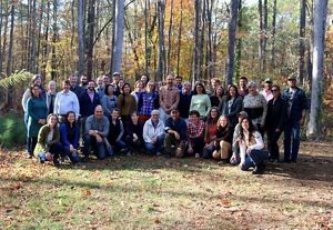 A group picture of all the North Carolina staff members. The group is standing in front of trees that have fall-like colors.