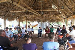 Network meeting with several people gathered in a circle in an open air room. 