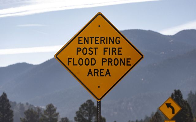A road sign with mountains in the background.