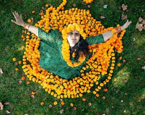 Neha Misra from above, standing in a circle of orange marigolds.