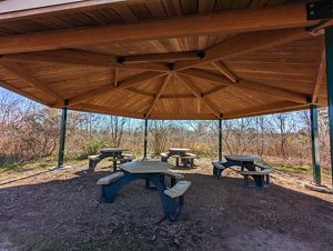 Four picnic tables under a shaded gazebo.