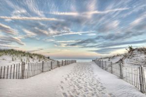 A beach path with footprints leading to the ocean.
