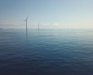 An aerial view of ocean with wind turbines.
