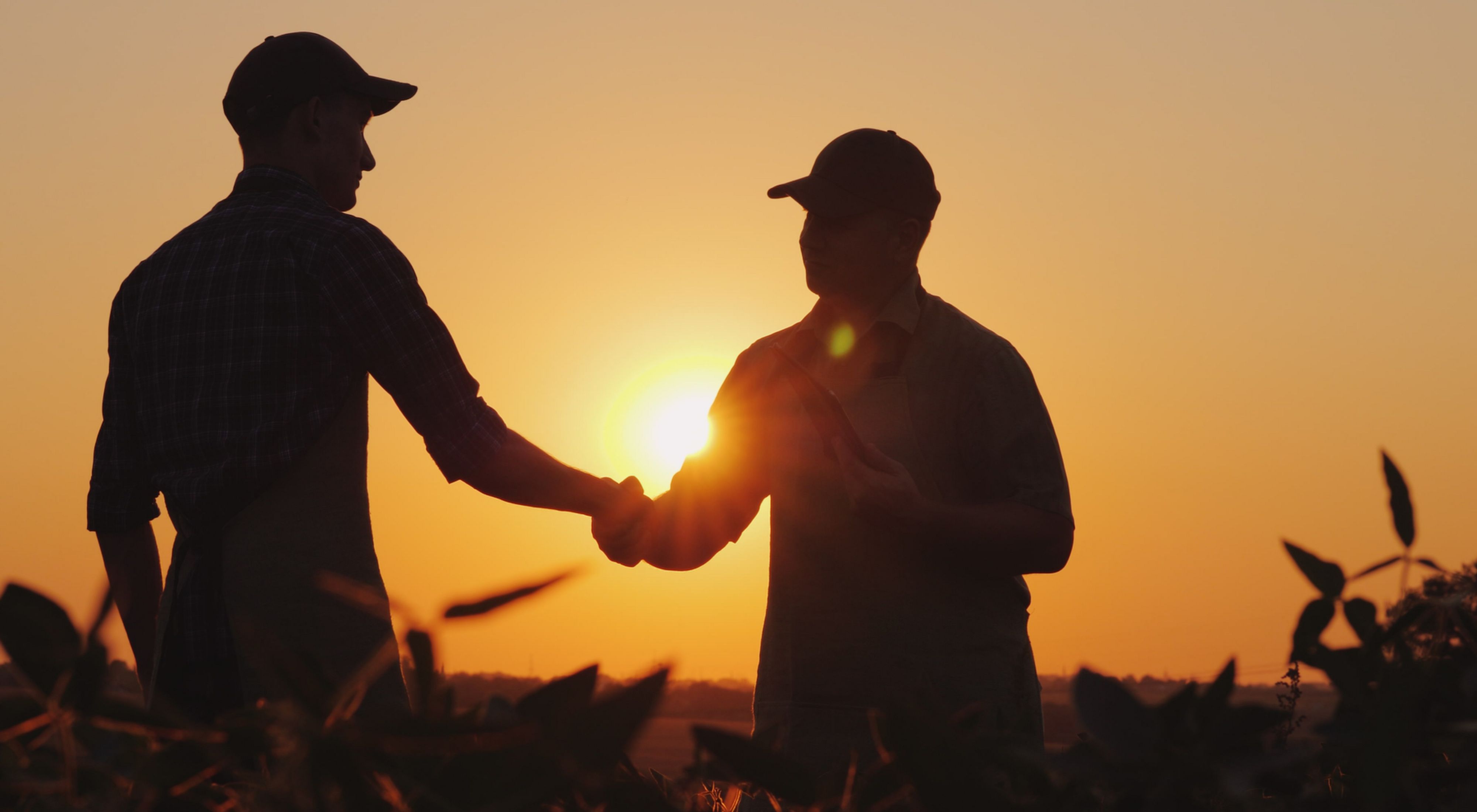 Two men in a farm field. Improved soil health. Everyone profits. Everyone thrives.
