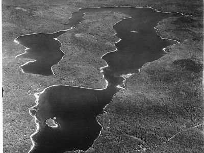 An aerial view of of a wooded peninsula between two lakes.