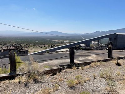 View of an old mill in Nevada with mountains in the background.
