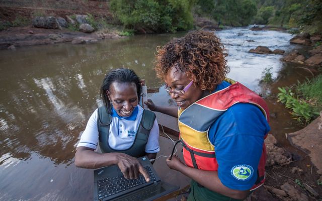 Faith Mbathi and Jane Njoroge measure water quality and quantity in Gura River for the Upper Tana-Nairobi Water Fund.