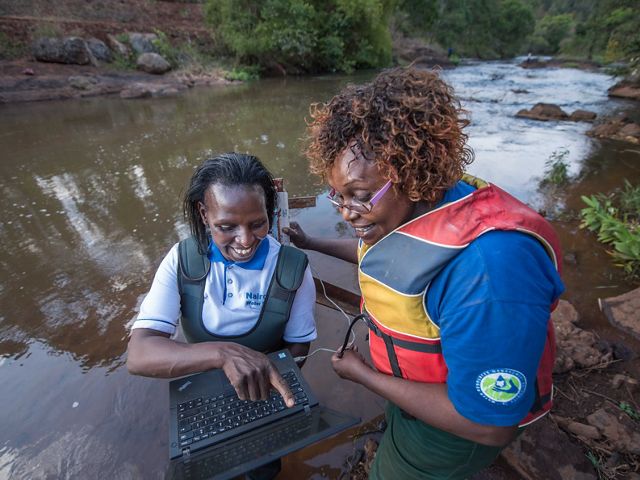 Faith Mbathi (left) and Jane Njoroge (right) of Kenya's Water Resources Authority use technology to measure water flows as part of the Water Fund.