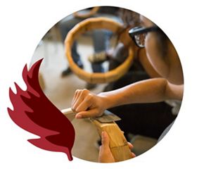 An Indigenous artisan carves wood by hand.