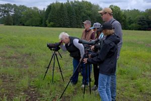 TNC staff and visitors look through viewing scopes at Sandhill Crane Wetlands.