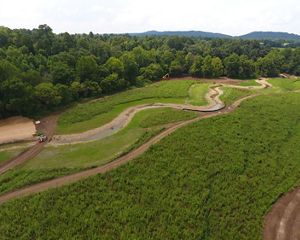 Aerial view of construction equipment and crews helping restore Strait Creek, which winds through a grassy landscape.