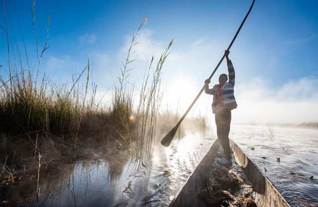 A man, checking his fishing nets in the lagoon on the Cuito River, Livambi village.