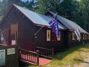 A picture of a building and its lawn with a flag on it. 